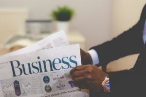 A photo of a man holding the business newsletter learning personal finance tips.