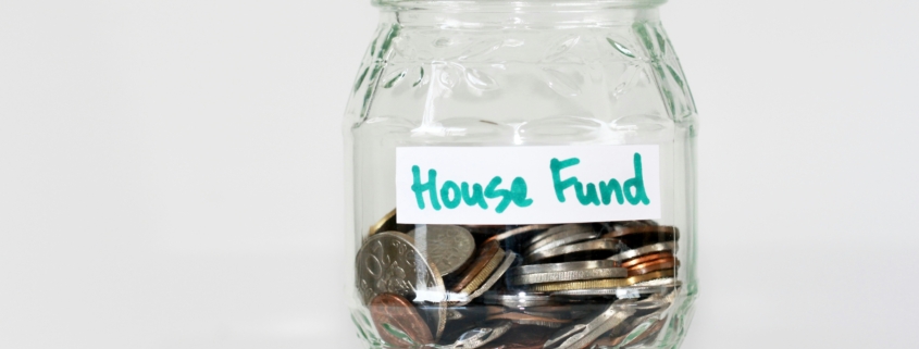 an image of a piggy bank house fund, which is one personal finance tip Navy & Sage benefits recommends setting up.