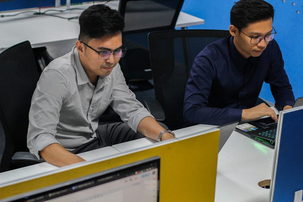 two men at work creating a growth mindset through fostering resilience at work. 